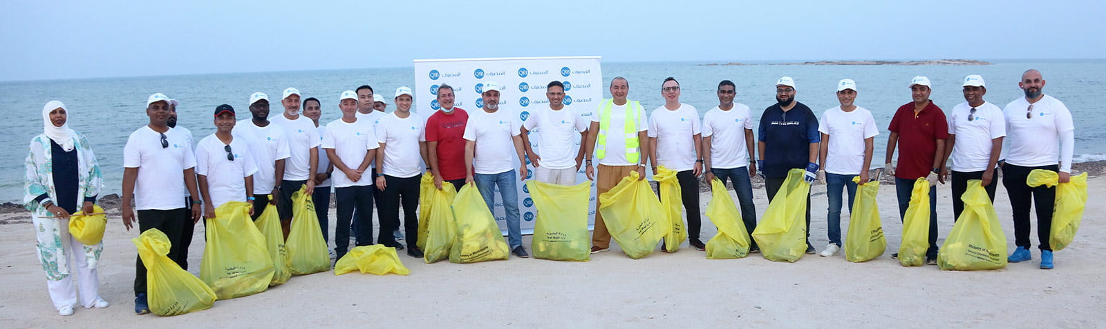 Home banner showing employee beach cleaning initiative group activity.