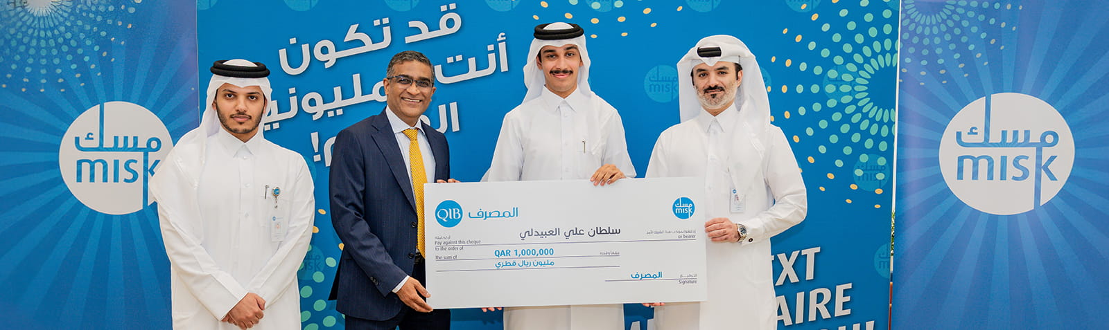 يقف التنفيذيون معا داخل المنازل مع خلفية تحمل علامة تجارية خلال حفل التكريم.