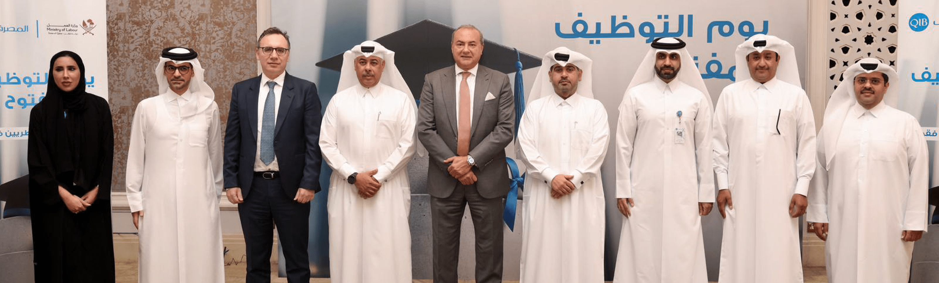 مجموعة من التنفيذيين يقفون جنبا إلى جنب في الداخل خلال اجتماع رسمي.