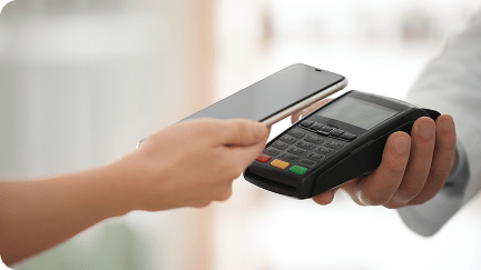 Contactless payment underway with a phone held near a payment terminal.