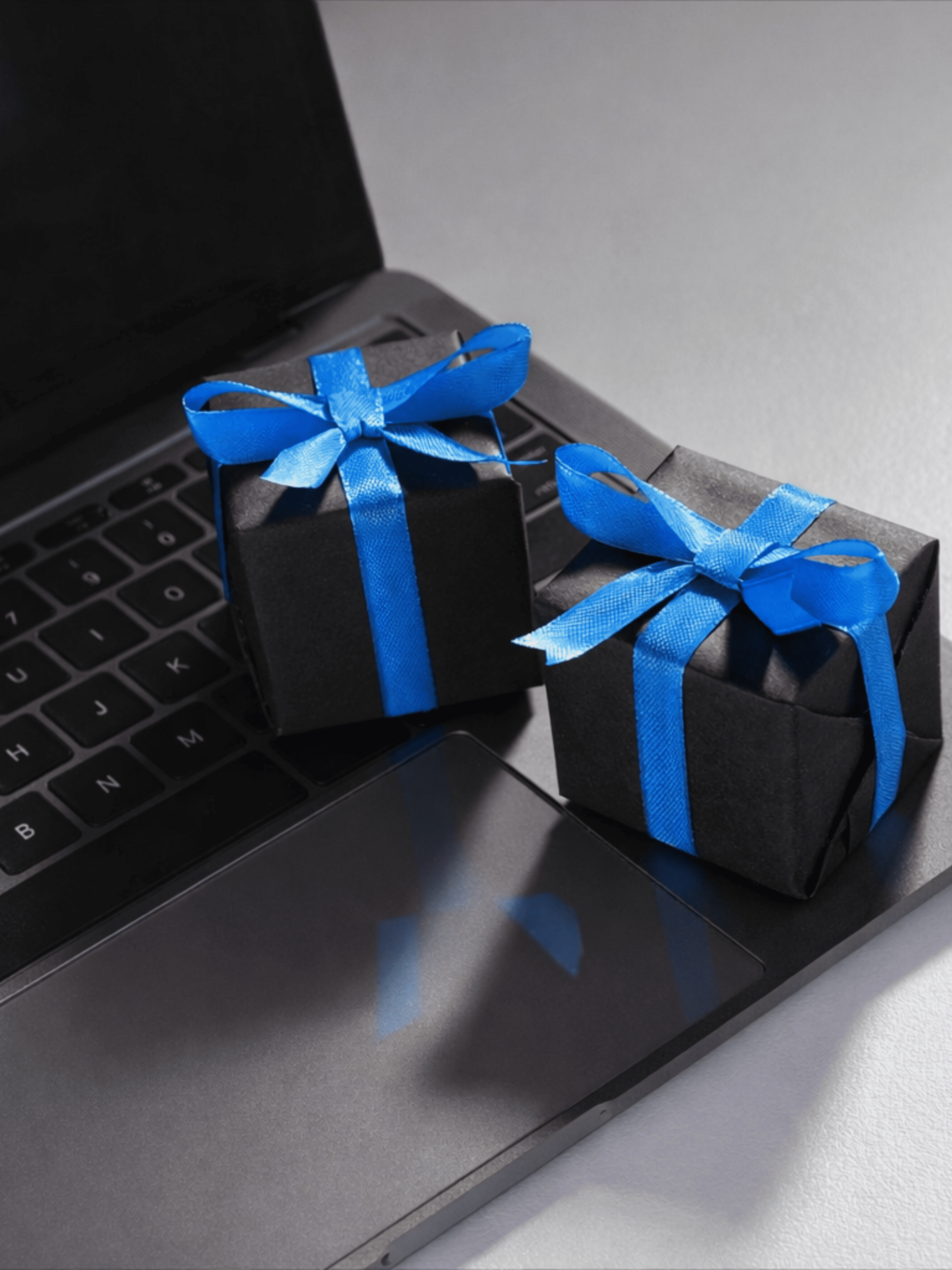 Two blue gift boxes placed on a dark surface, representing reward points exchange and gifts.